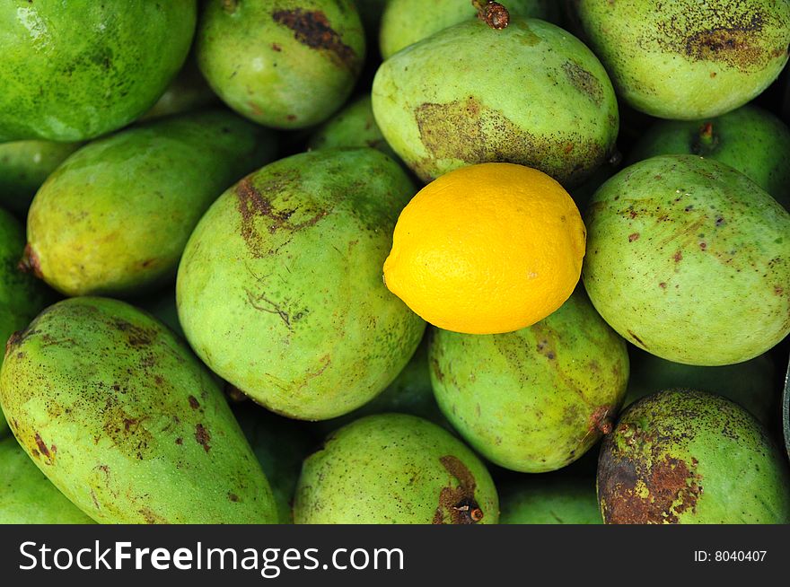 Green mangoes and yellow lemon