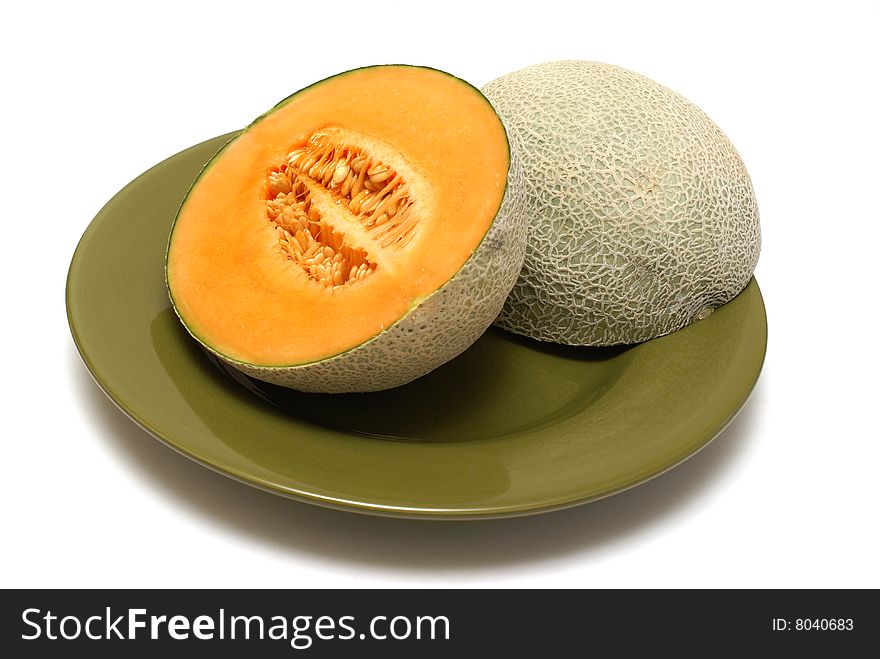 A freshly cut cantaloupe on a dinner plate. A freshly cut cantaloupe on a dinner plate.