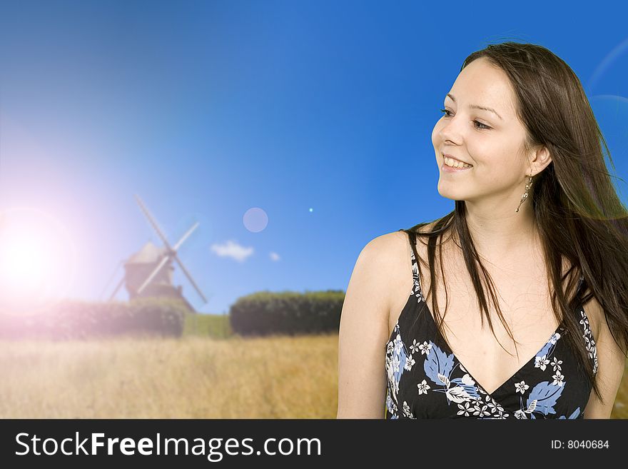 Girl over windmill in wide field in brittany in france