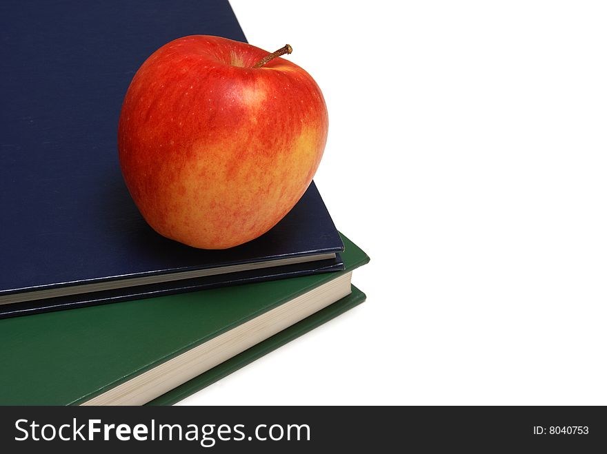 An apple resting on a couple of textbooks. An apple resting on a couple of textbooks.