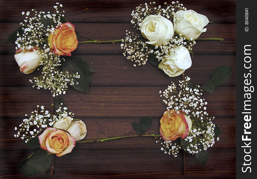 Roses and Baby's breath form a frame on an old wall of barn wood. Roses and Baby's breath form a frame on an old wall of barn wood