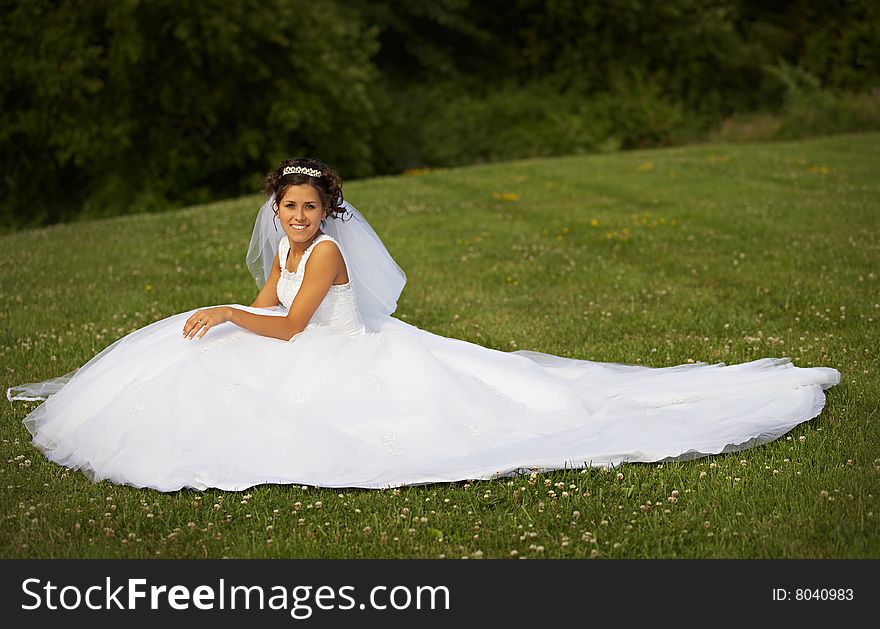 The bride sitting on grass