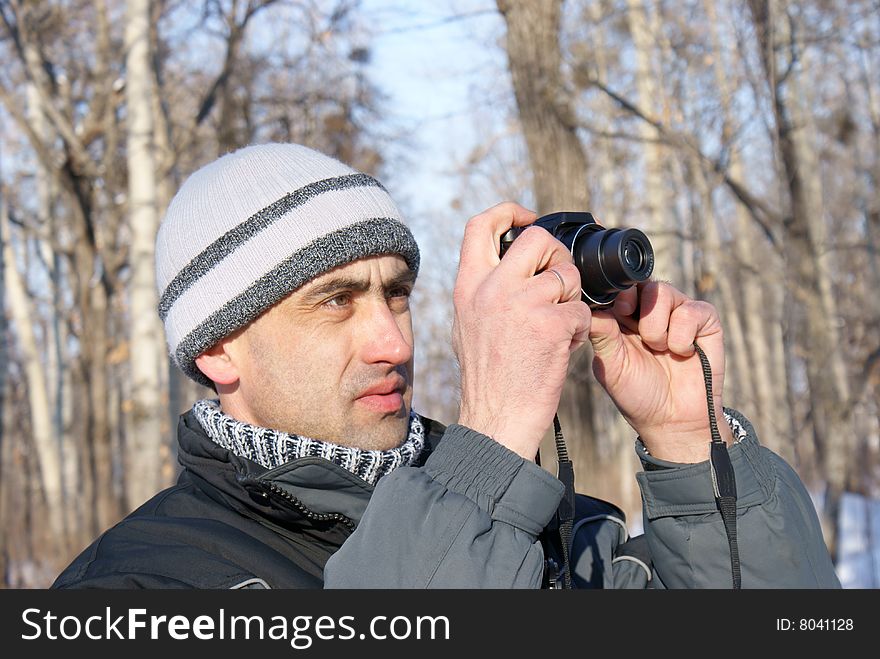 The man photographes in the winter, In a wood