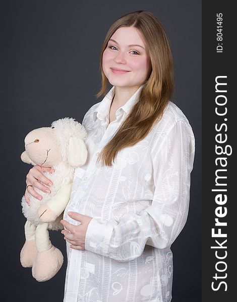 Beautiful pregnant woman holding toy