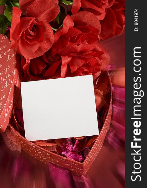 Heart shaped gift box with some roses over it and white note. Heart shaped gift box with some roses over it and white note
