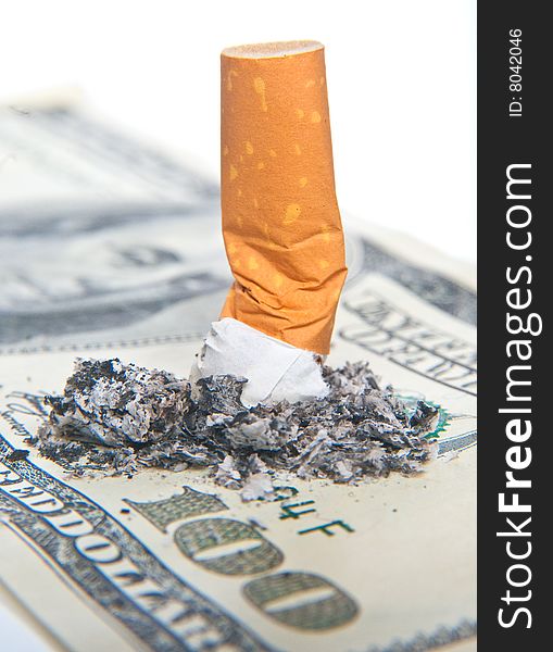 Cigarette laying on 100 dollars bill. Cigarette laying on 100 dollars bill