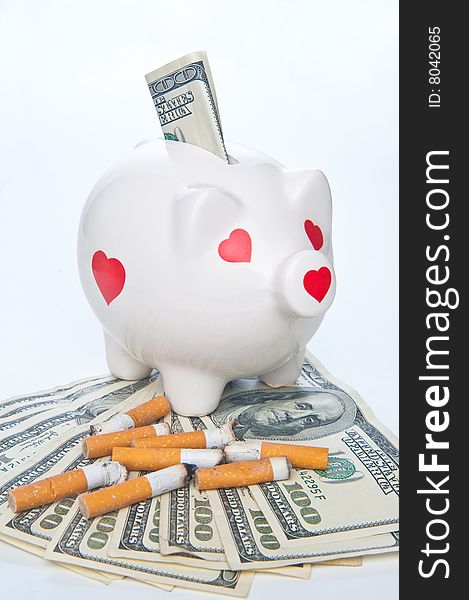 Piggybank and cigarette butts standing on 100 dollars bills. Piggybank and cigarette butts standing on 100 dollars bills