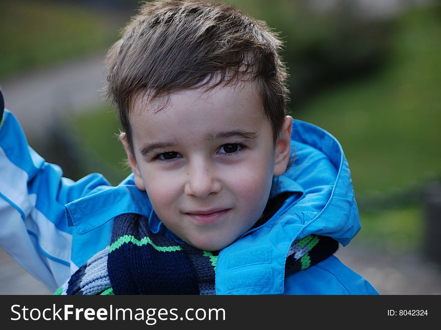 Boy in a blue jacket in an autumn park