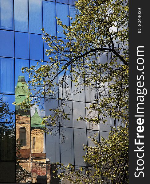 The old church is reflected in a modern building