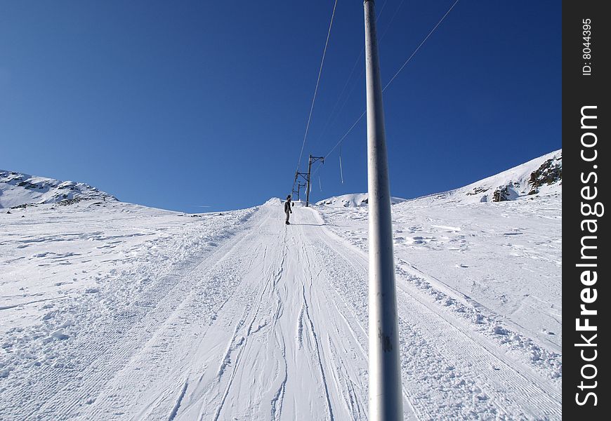 Ski lift pulling skier to the blue sky