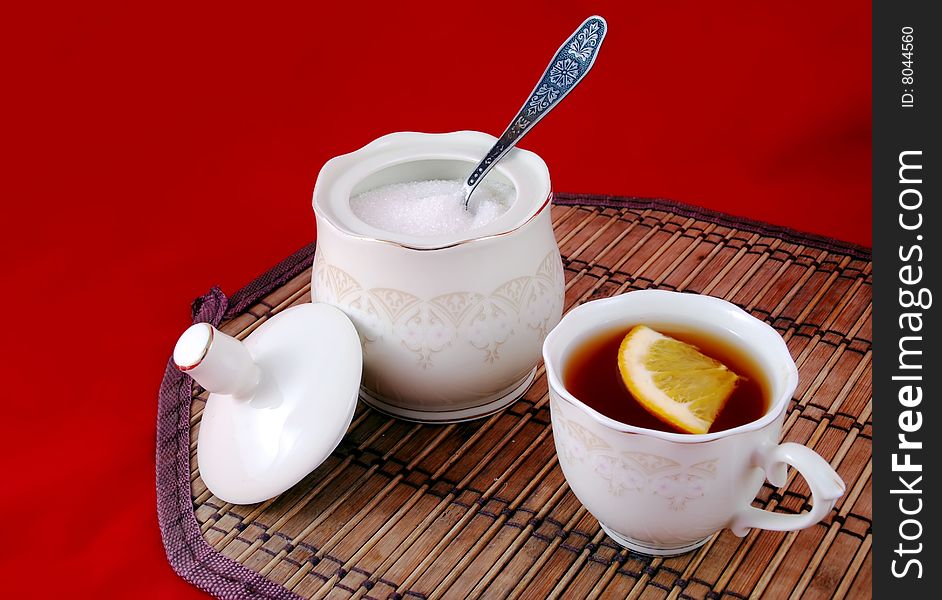 Beautiful still life cup of tea and lemon with sugar.