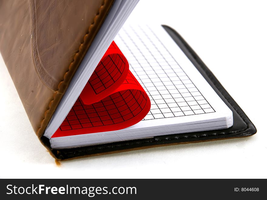 Notebook and a silver pen isolated on a white background