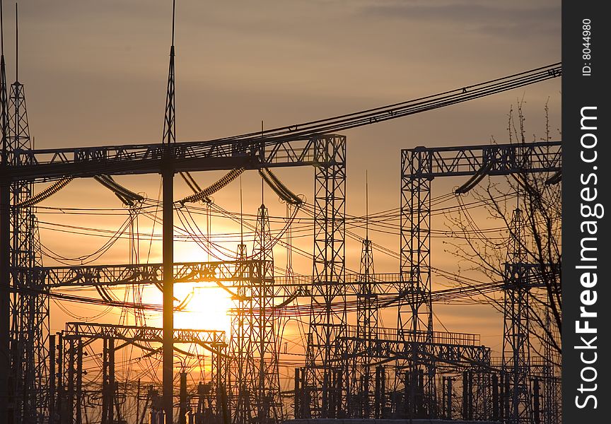 Sun setting behind a row of electricity pylons. Sun setting behind a row of electricity pylons