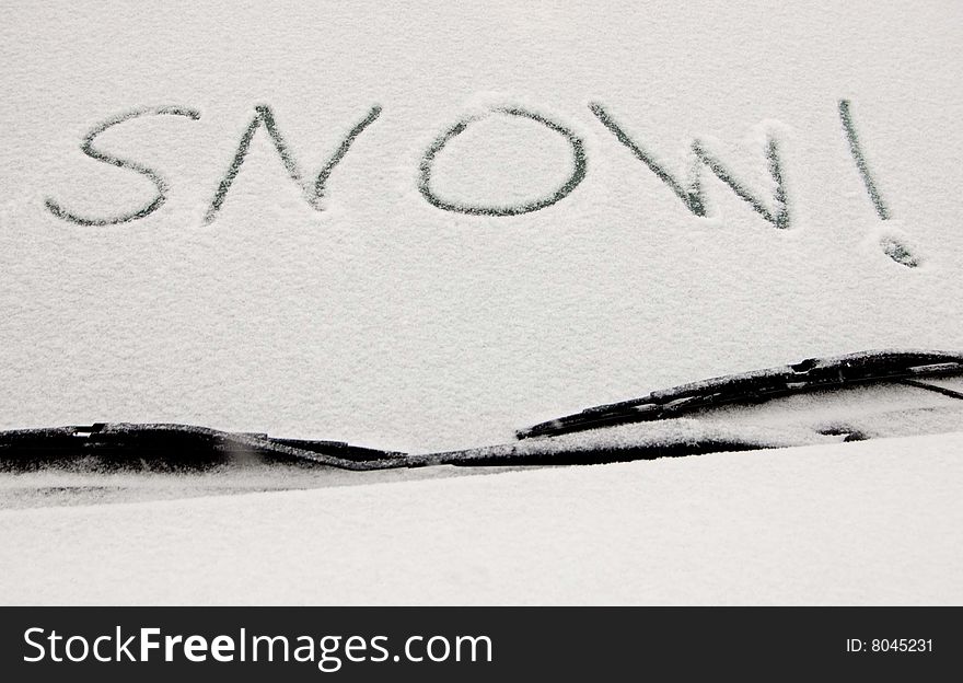 Snow! written in snow across car windshield