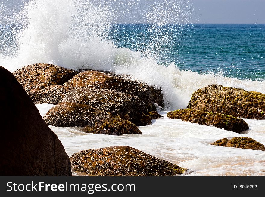 Splashing on seaside at sunny day in Kerala, India