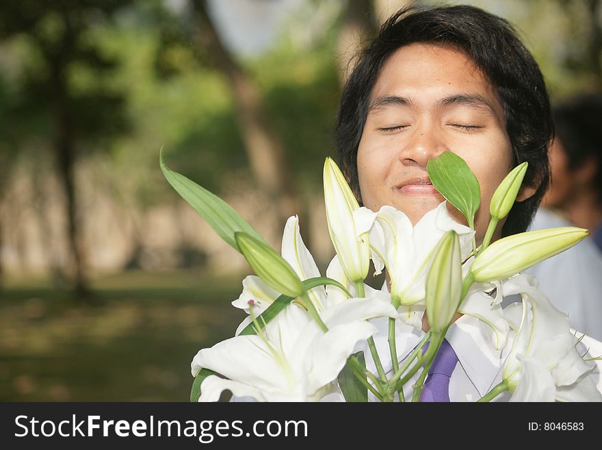 A guy smelling flowers in the garden. The smell of sucess!