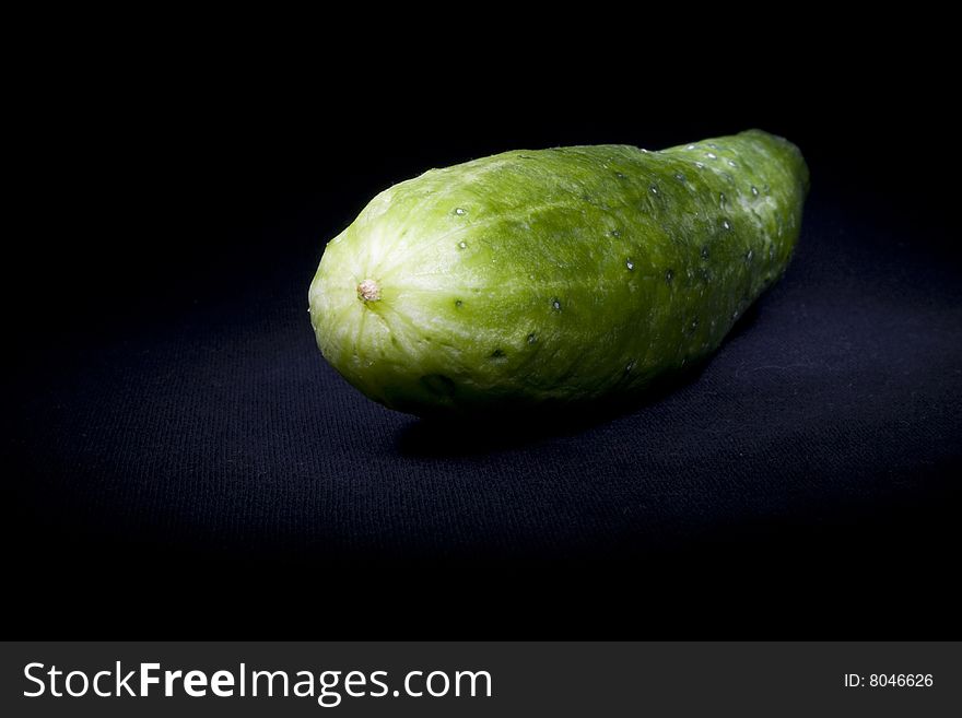 Fresh green cucumber not isolated on black. Fresh green cucumber not isolated on black