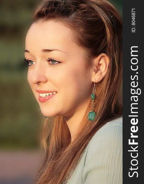 Portrait of a beautiful young lady in golden light of summer sunset