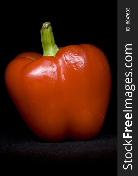 Red pepper on the black not isolated background