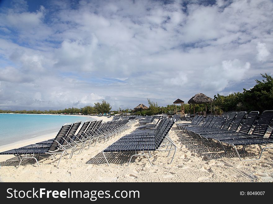 Aqua blue beach ocean with many chairs for relaxing. Aqua blue beach ocean with many chairs for relaxing