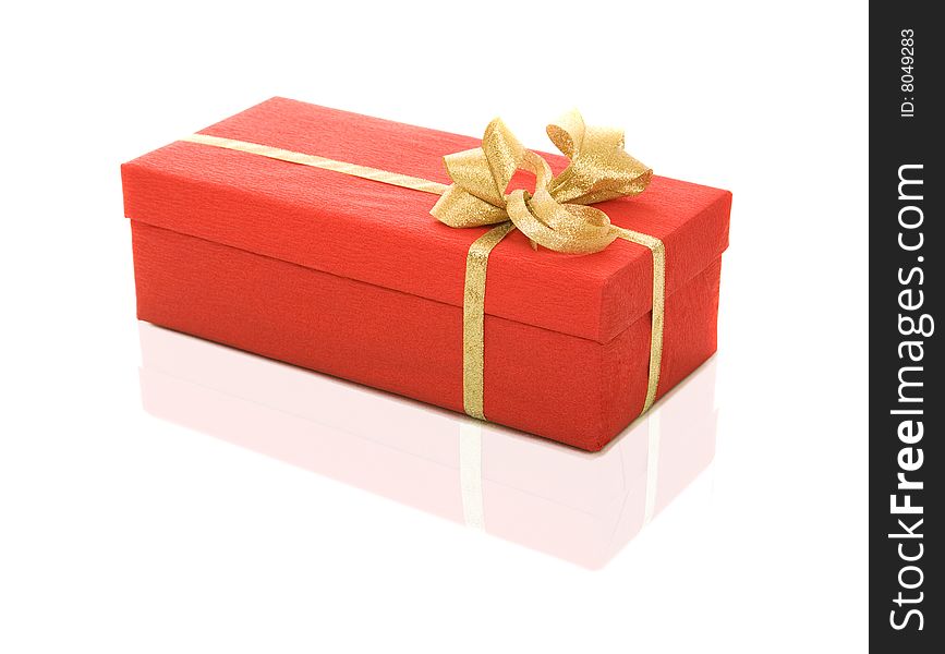 Red gift box over white background with gold ribbon