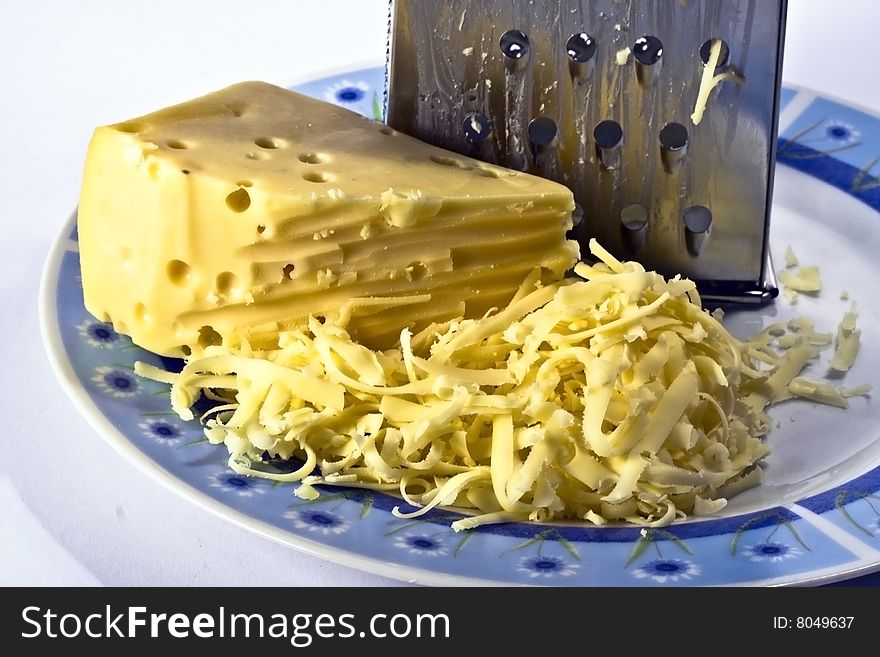 Grated cheese and the grater. Cheese as an ideal component for casserole.