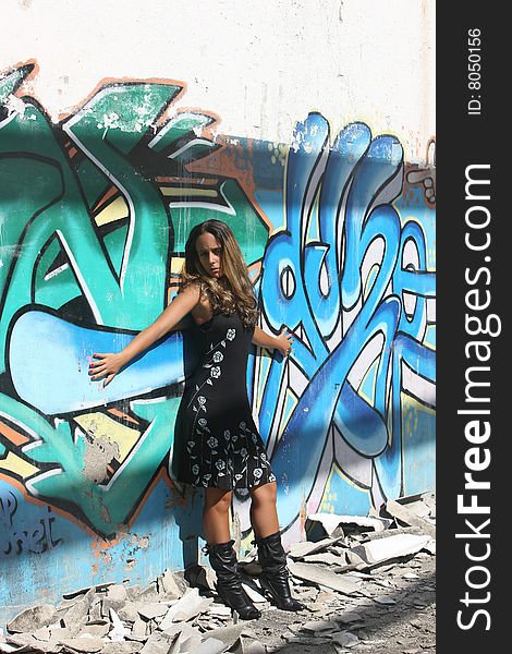 Woman with open arms in a wall with graffiti