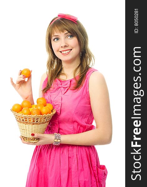 Beautiful young woman dressed in a pink dress with a basket full of tangerines. Beautiful young woman dressed in a pink dress with a basket full of tangerines