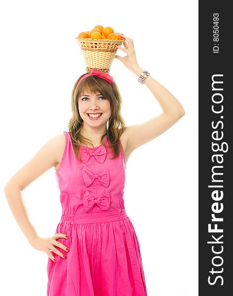 Portrait of a beautiful young cheerful woman dressed in pink with a basket full of tangerines on her head. Portrait of a beautiful young cheerful woman dressed in pink with a basket full of tangerines on her head