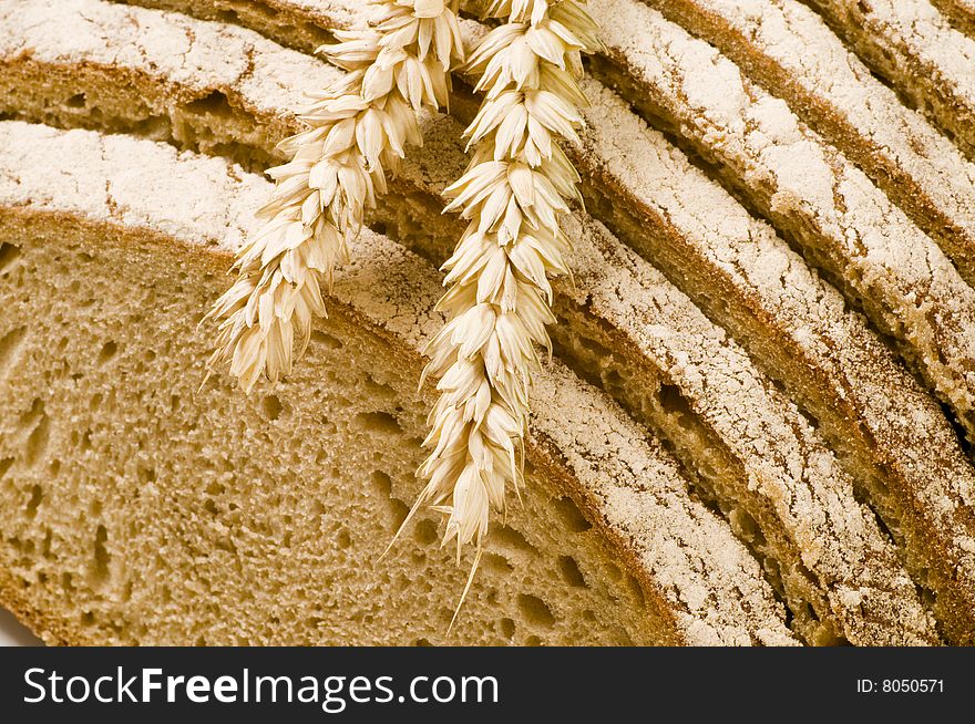 Macro of two wheat ears lying on sliced bread. Macro of two wheat ears lying on sliced bread