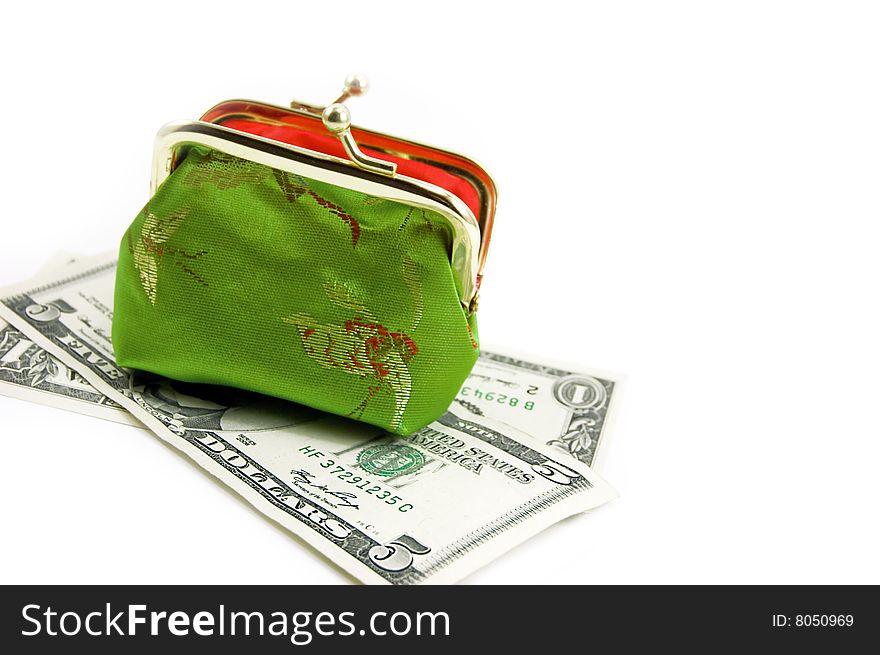 Green purse over dollar banknotes on white. Green purse over dollar banknotes on white