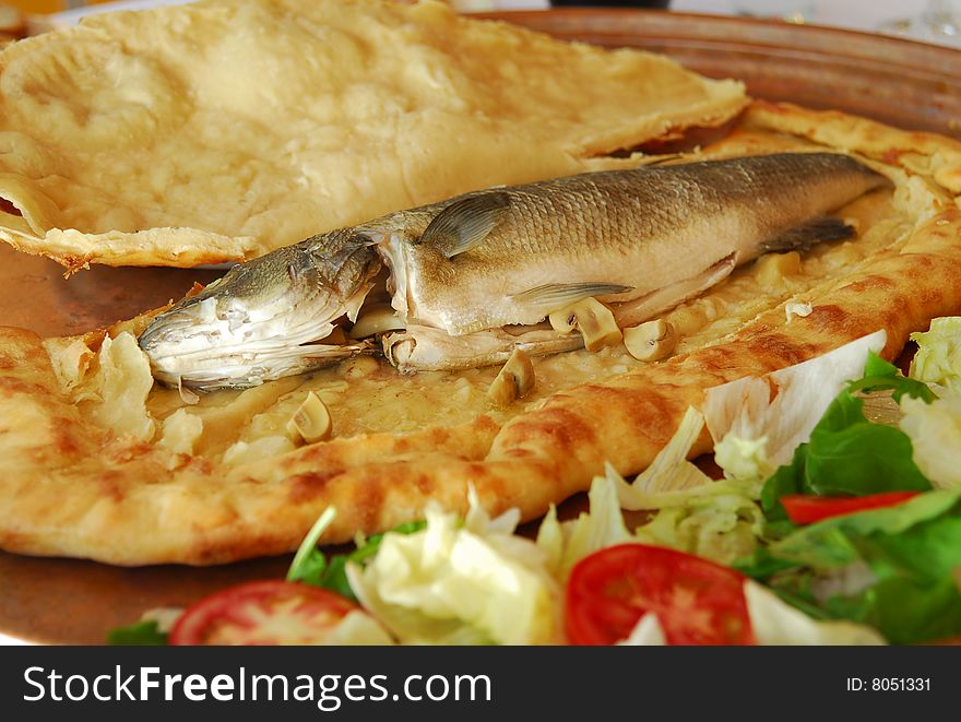 traditional turkish and mediterranean seafood, Sea bass in cooking in the pitta serving with wine or turkish traditional drink raki. traditional turkish and mediterranean seafood, Sea bass in cooking in the pitta serving with wine or turkish traditional drink raki