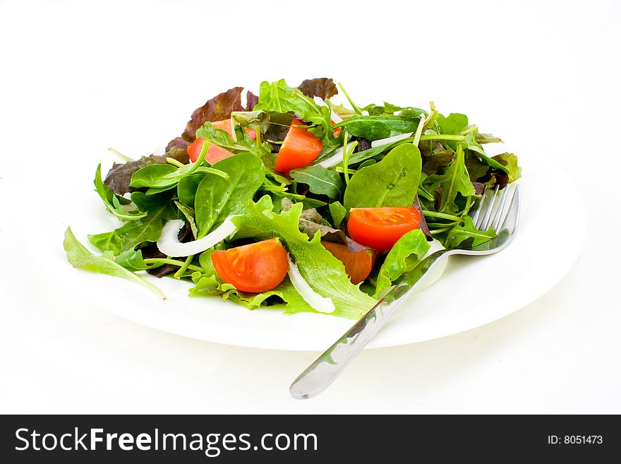 Fresh salad with fork on white background