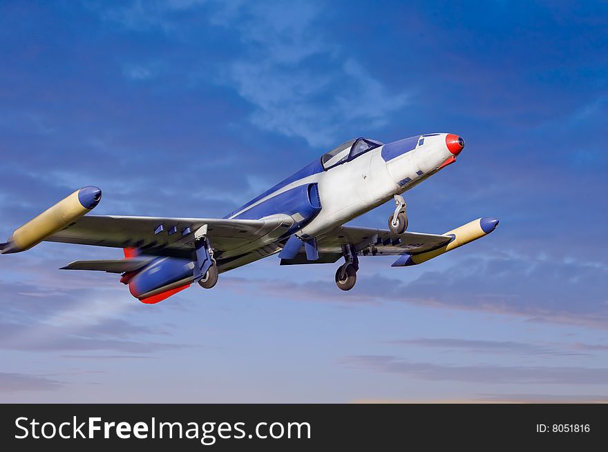 Old time jet fighter on blue cloudy sky