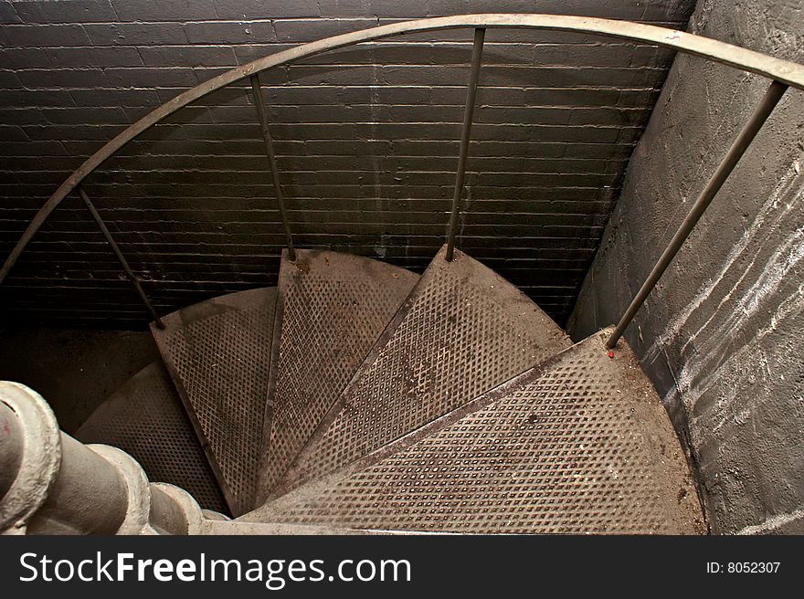 Looking down spiral staircase trailing off into darkness