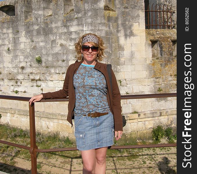 A woman tourist is posing in front of a landmark on vacation. A woman tourist is posing in front of a landmark on vacation