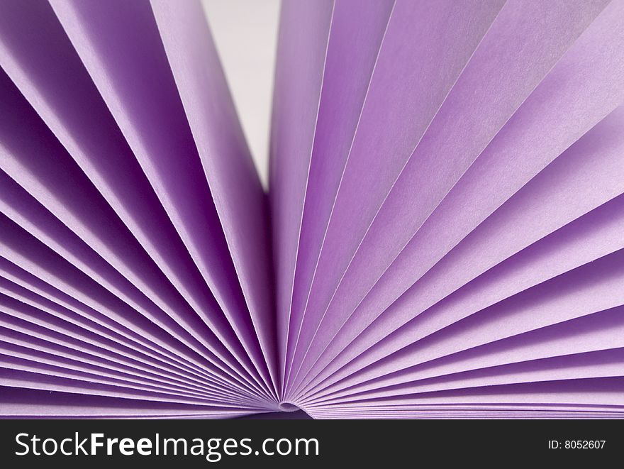 Opened stack of notes violet colors isolated on white