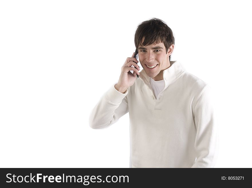 A young man talking on his phone in front of an isolated background. A young man talking on his phone in front of an isolated background