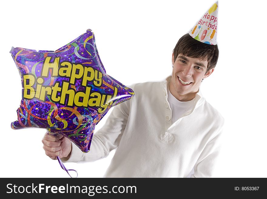 A young man is holding a birthday balloon out for the camera. A young man is holding a birthday balloon out for the camera