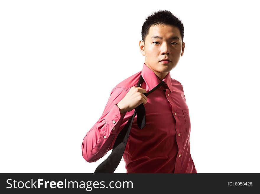 Stylish asian young man in pink shirt untying black tie. Stylish asian young man in pink shirt untying black tie