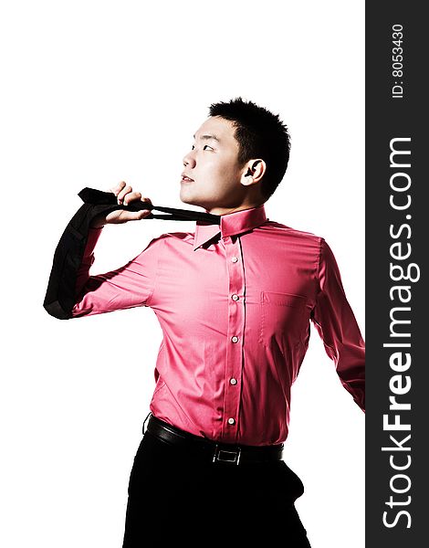 Stylish asian young man pulling the tie on his neck. Stylish asian young man pulling the tie on his neck