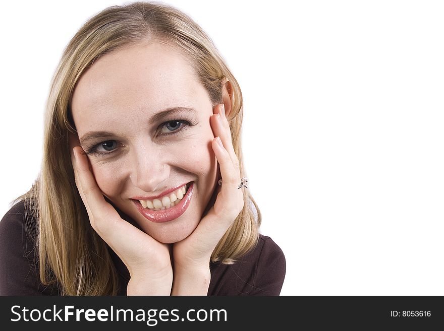 A pretty girl with her head in her hands smiles at the camera in front of a white background. A pretty girl with her head in her hands smiles at the camera in front of a white background