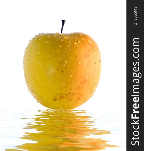 Stock photo: an image of a big yellow apple with drops of water on it