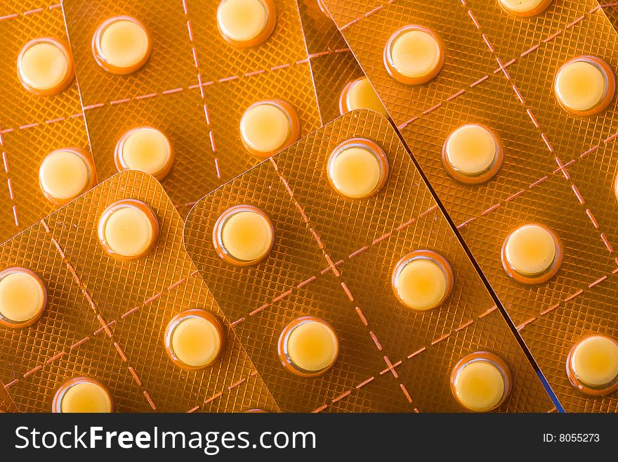 Stock photo: medical  theme: an image of orange tablets in blisters closeup