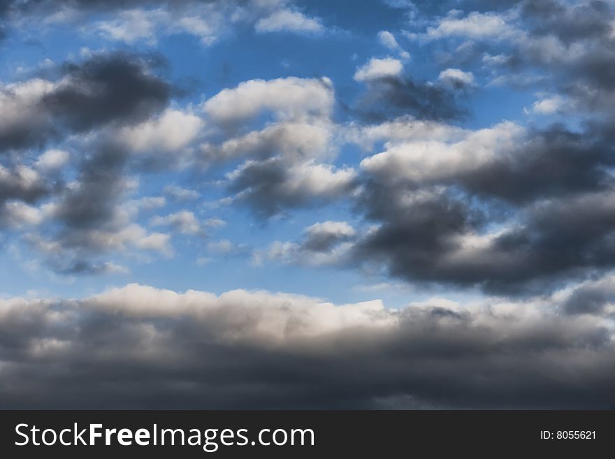 Blue sky background with white and dark clouds