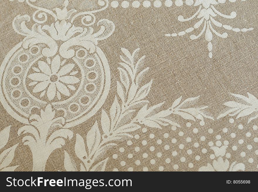 A detail of gray linen fabric with printed white ornaments. A detail of gray linen fabric with printed white ornaments