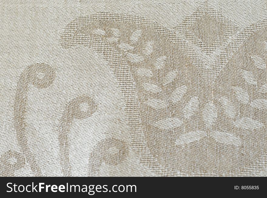 A detail of gray linen fabric with woven  ornaments. A detail of gray linen fabric with woven  ornaments