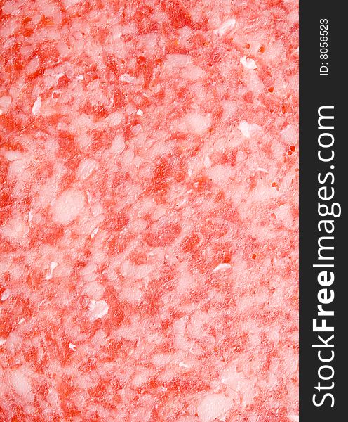 A close-up of the texture of a slice of salami. A close-up of the texture of a slice of salami