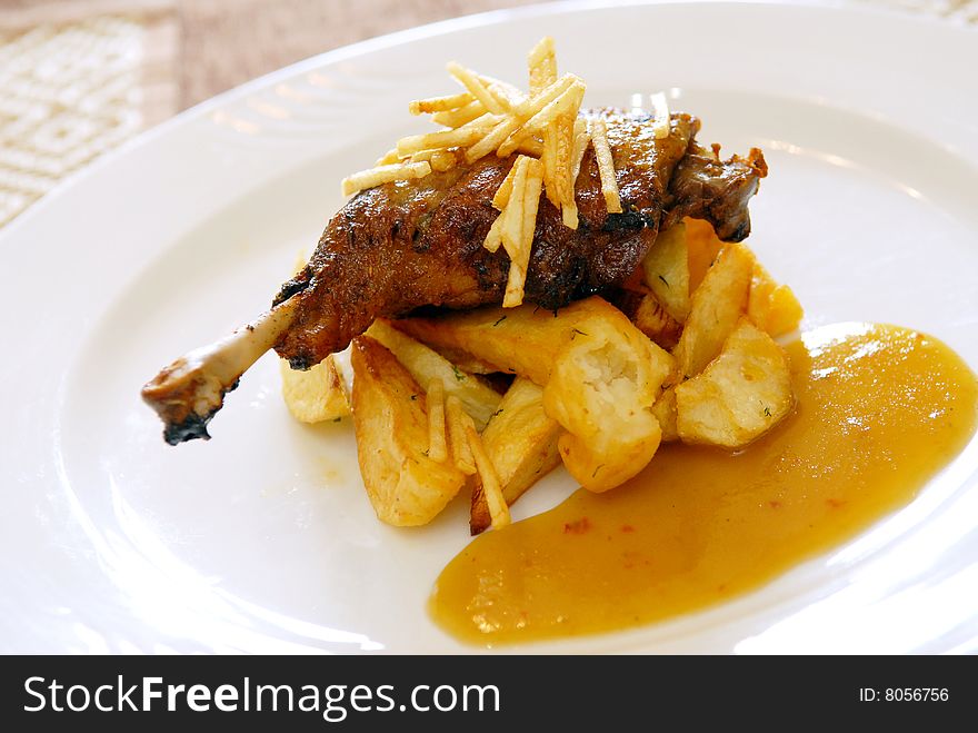 Fried chicken leg with a potato and sauce