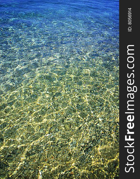 Beach pebbles under clear water with waves. Beach pebbles under clear water with waves